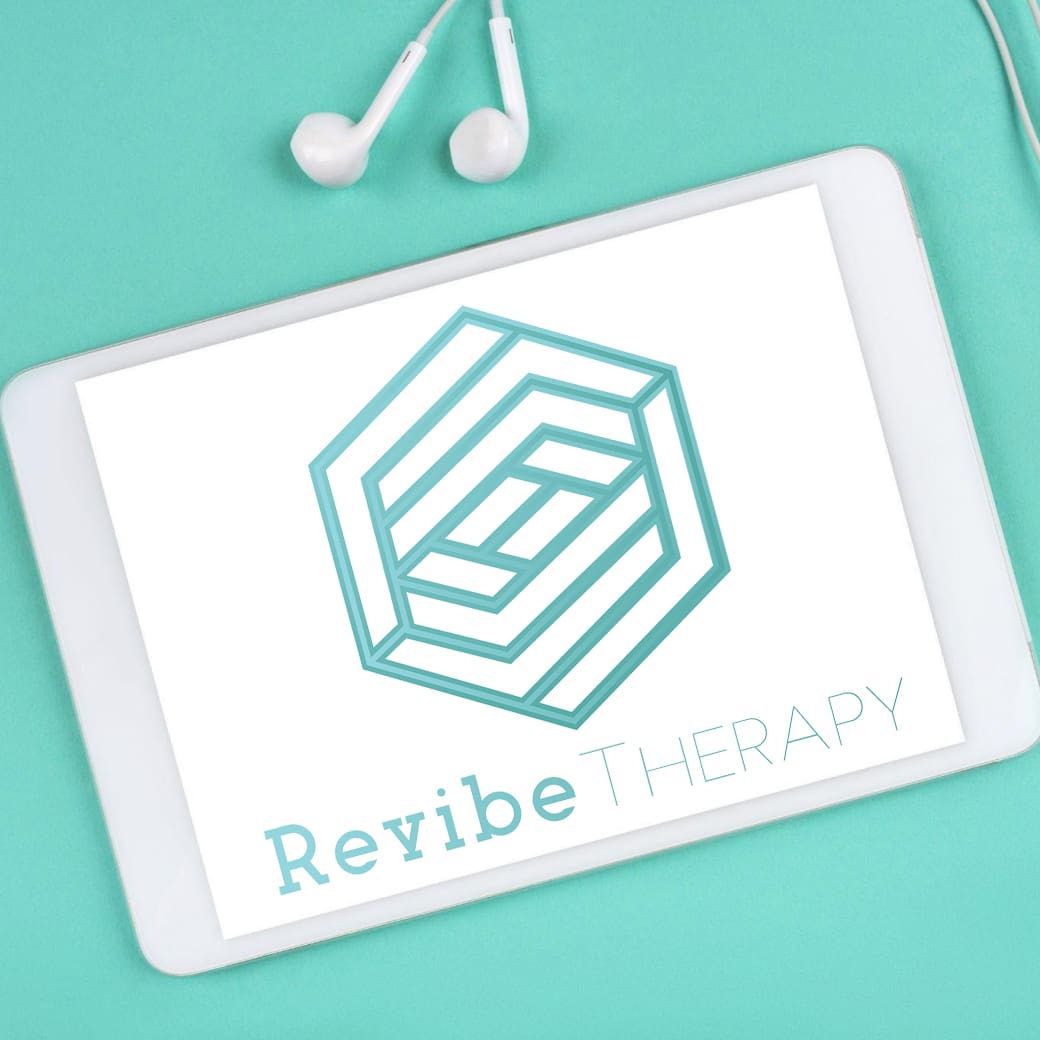 A tablet displaying the logo for Revibe Therapy, which features a geometric design and the text "Revibe Therapy." Earphones are placed beside the tablet, all set against a teal background.