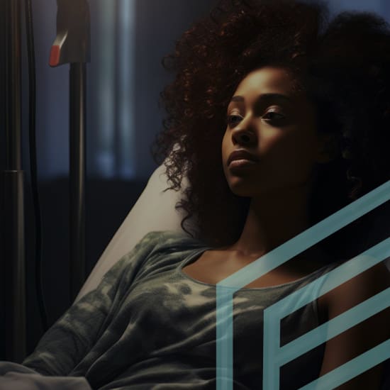 A woman with curly hair lies in a hospital bed, looking contemplative. The scene is dimly lit, creating a serene yet somber mood. Medical equipment is partially visible in the background.