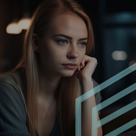 A young woman with long, blonde hair sits thoughtfully, resting her chin on her hand. She is set against a dark, blurred background, giving a contemplative mood. Light from a nearby source softly illuminates her face, revealing a calm expression.