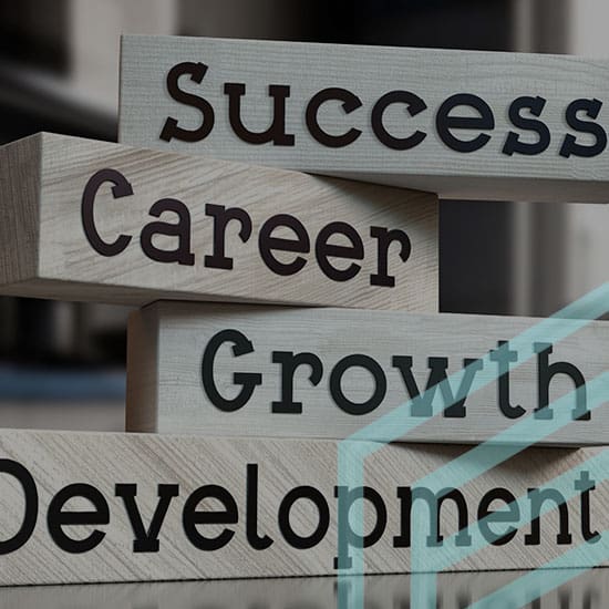 Wooden blocks with the words "Success," "Career," "Growth," and "Development" are stacked in ascending order, symbolizing progression and achieving goals. The background is blurred, highlighting the focus on the blocks.