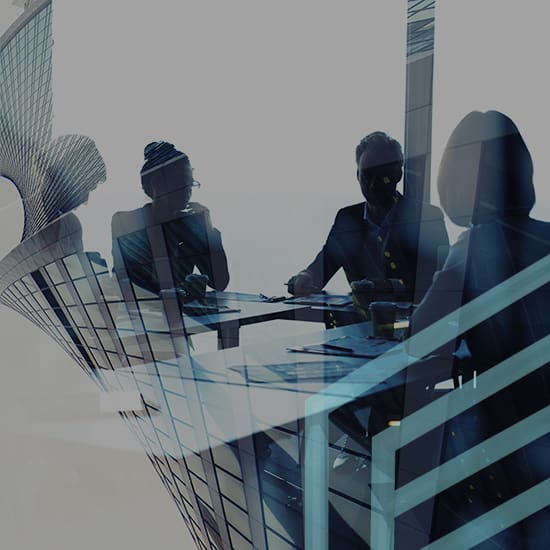 Silhouettes of four people in a business meeting sit around a table with laptops and papers in front of them. The image is overlapped with an abstract architectural pattern of a modern building, creating a double exposure effect.